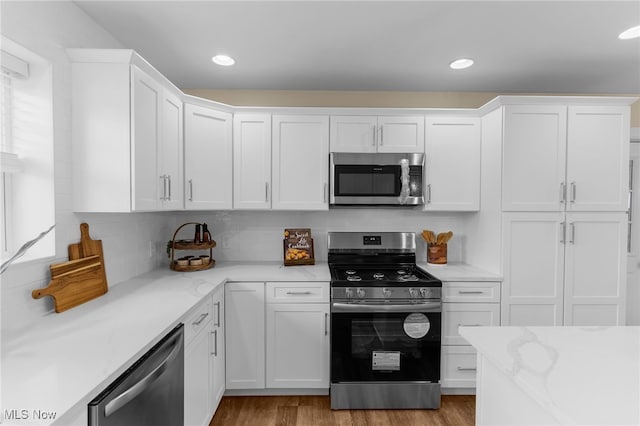 381 Lauretta Ln, Hubbard, OH 44425 - kitchen featuring stainless steel appliances, white cabinetry, backsplash, recessed lighting, and wood finished floors