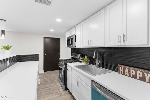 381 Lauretta Ln, Hubbard, OH 44425 - kitchen with stainless steel appliances, light countertops, white cabinetry, light wood finished floors, and recessed lighting
