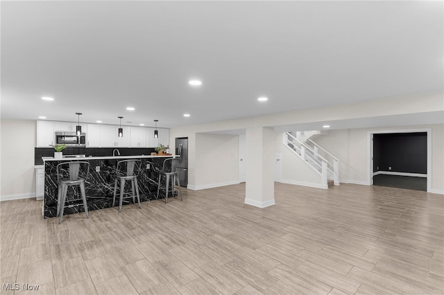 381 Lauretta Ln, Hubbard, OH 44425 - kitchen with stainless steel appliances, recessed lighting, open floor plan, a kitchen bar, and white cabinets