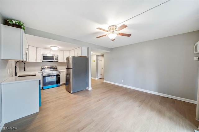 1372 Golden Gate Blvd, Mayfield Heights, OH 44124 - kitchen with appliances with stainless steel finishes, ceiling fan, light countertops, light wood-type flooring, and white cabinets