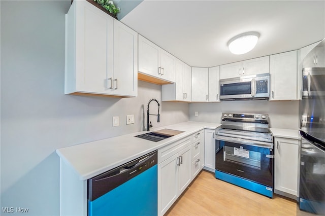 1372 Golden Gate Blvd, Mayfield Heights, OH 44124 - kitchen with stainless steel appliances, white cabinets, light wood-style floors, and light countertops