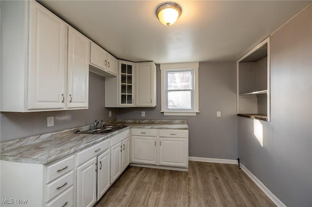 3888 W 37th St, Cleveland, OH 44109 - kitchen with light wood-style flooring, glass insert cabinets, and white cabinets