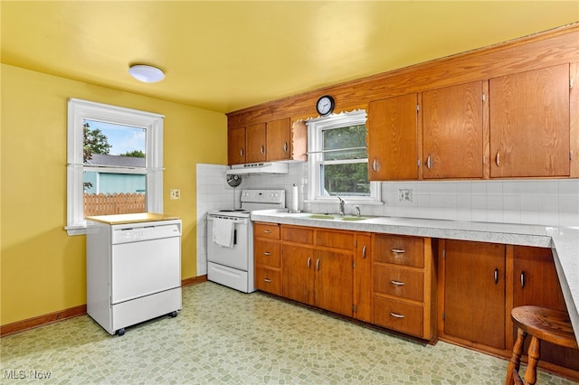 15459 Serfass Rd, Doylestown, OH 44230 - kitchen with white appliances, under cabinet range hood, tasteful backsplash, and brown cabinets