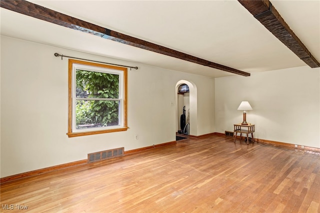 15459 Serfass Rd, Doylestown, OH 44230 - empty room with beamed ceiling, arched walkways, and light wood-style flooring
