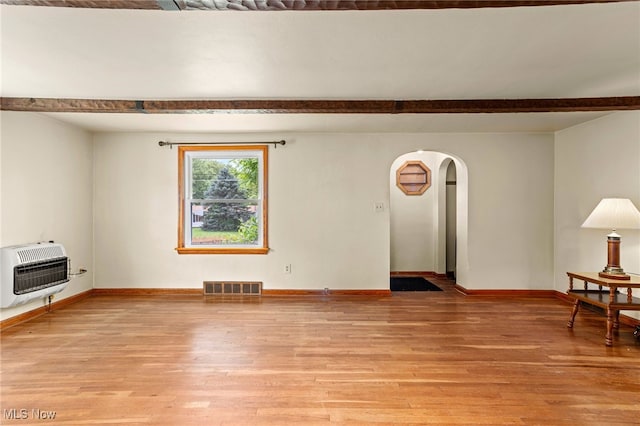 15459 Serfass Rd, Doylestown, OH 44230 - unfurnished living room with heating unit, arched walkways, light wood-type flooring, and beam ceiling