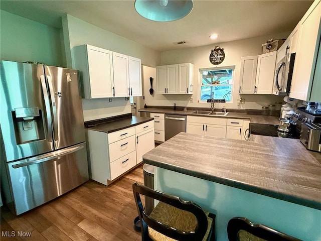 1550 Swift Rd, Waterford, OH 45786 - kitchen featuring stainless steel appliances, dark countertops, white cabinetry, dark wood-type flooring, and a peninsula