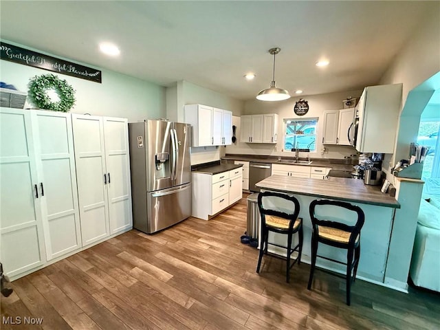1550 Swift Rd, Waterford, OH 45786 - kitchen with stainless steel appliances, dark countertops, dark wood-type flooring, white cabinets, and recessed lighting