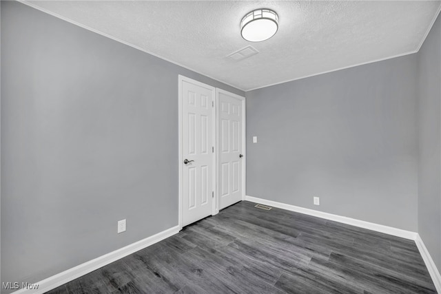 7569 Lake Shore Blvd, Madison, OH 44057 - unfurnished bedroom with a textured ceiling, dark wood-style floors, and crown molding