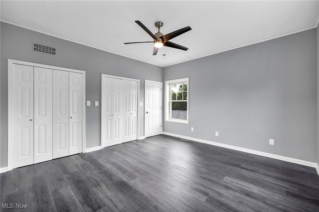 7569 Lake Shore Blvd, Madison, OH 44057 - unfurnished bedroom featuring dark wood-type flooring, two closets, and ceiling fan
