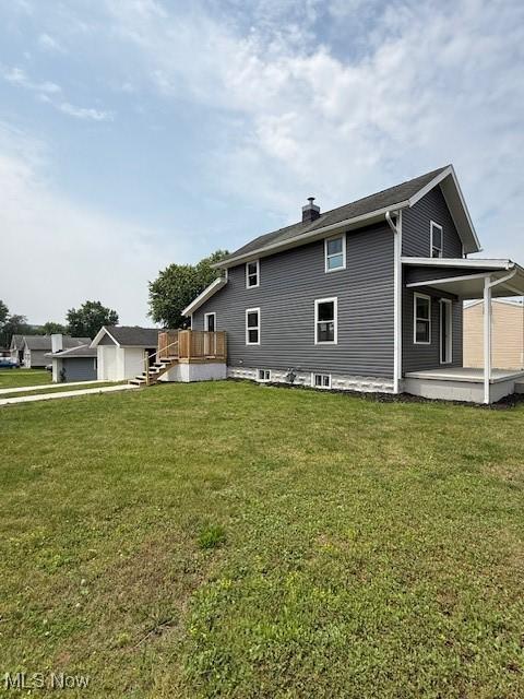 637 Maple St, Newcomerstown, OH 43832 - rear view of property featuring a chimney, a yard, and a deck