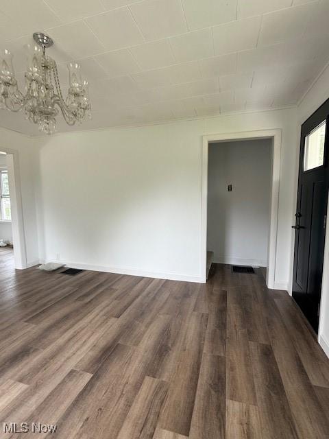 637 Maple St, Newcomerstown, OH 43832 - unfurnished dining area with a chandelier and dark wood finished floors