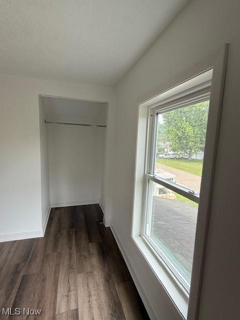 637 Maple St, Newcomerstown, OH 43832 - unfurnished bedroom featuring dark wood-style flooring, a textured ceiling, and a closet