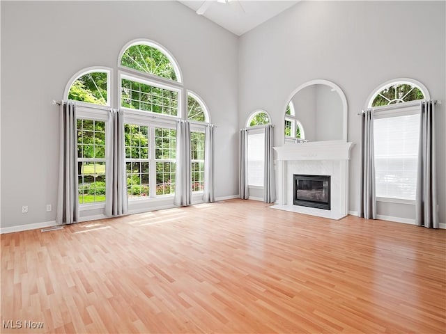 32969 Durrell Ave, Avon Lake, OH 44012 - unfurnished living room featuring light wood finished floors, healthy amount of natural light, a fireplace, and high vaulted ceiling