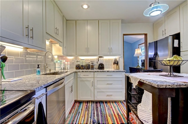 27008 Sweetbriar Dr, North Olmsted, OH 44070 - kitchen featuring stainless steel appliances, decorative backsplash, light stone countertops, white cabinetry, and recessed lighting