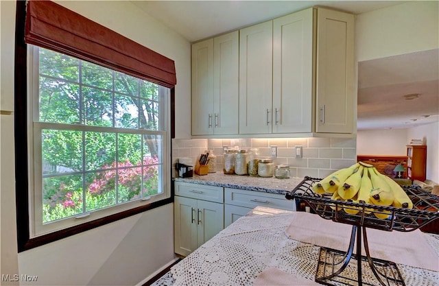 27008 Sweetbriar Dr, North Olmsted, OH 44070 - kitchen with healthy amount of natural light, decorative backsplash, and light stone countertops