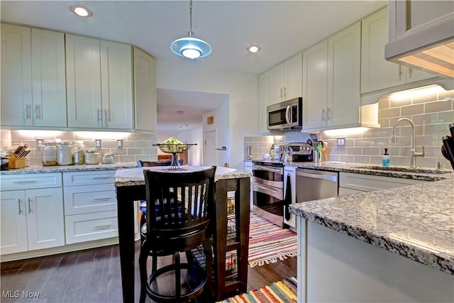 27008 Sweetbriar Dr, North Olmsted, OH 44070 - kitchen featuring stainless steel appliances, tasteful backsplash, dark wood-style flooring, and recessed lighting