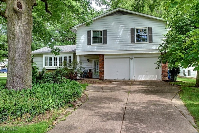 27008 Sweetbriar Dr, North Olmsted, OH 44070 - tri-level home featuring brick siding, a garage, and driveway