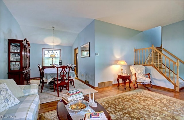27008 Sweetbriar Dr, North Olmsted, OH 44070 - living area featuring wood finished floors, stairs, vaulted ceiling, and a chandelier