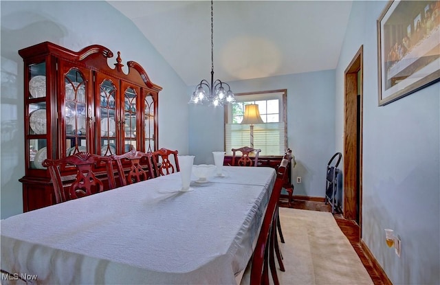 27008 Sweetbriar Dr, North Olmsted, OH 44070 - dining room with lofted ceiling, a chandelier, and wood finished floors