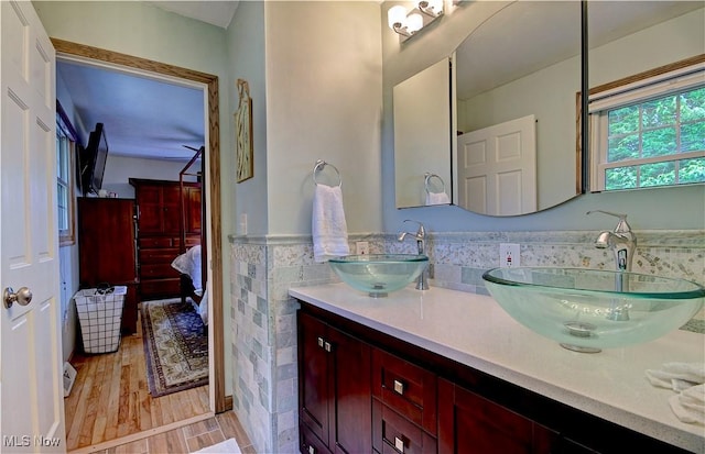 27008 Sweetbriar Dr, North Olmsted, OH 44070 - bathroom with tile walls, connected bathroom, double vanity, wainscoting, and wood finished floors