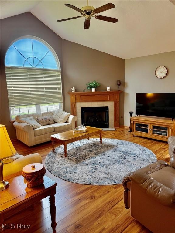 7536 Monterey Bay Dr Unit 2, Mentor-On-The-Lake, OH 44060 - living room featuring lofted ceiling, ceiling fan, a tiled fireplace, and wood finished floors
