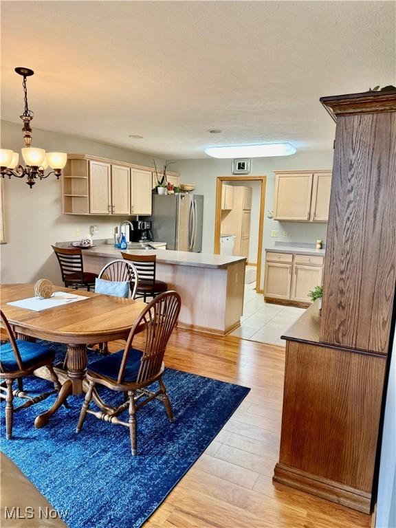 7536 Monterey Bay Dr Unit 2, Mentor-On-The-Lake, OH 44060 - dining area featuring light wood-type flooring, a chandelier, and washer / dryer