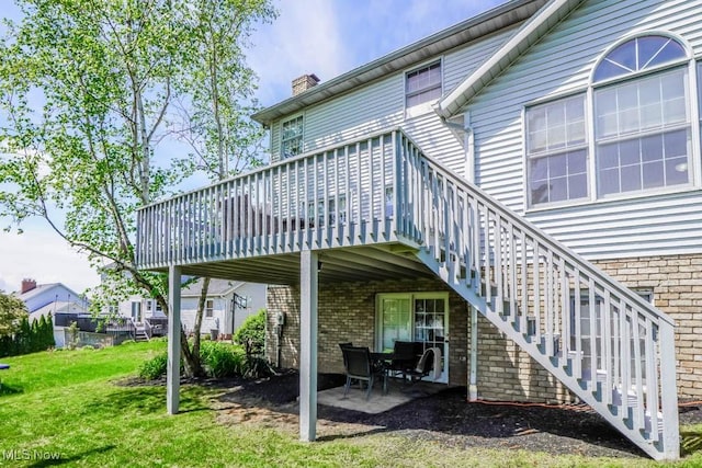 6202 Rockside Cir NW, Canton, OH 44718 - rear view of property featuring brick siding, a chimney, a deck, and a yard