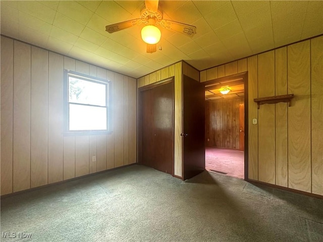 2178 Hewitt Gifford Rd SW, Warren, OH 44481 - unfurnished bedroom with carpet, ceiling fan, wood walls, and a closet