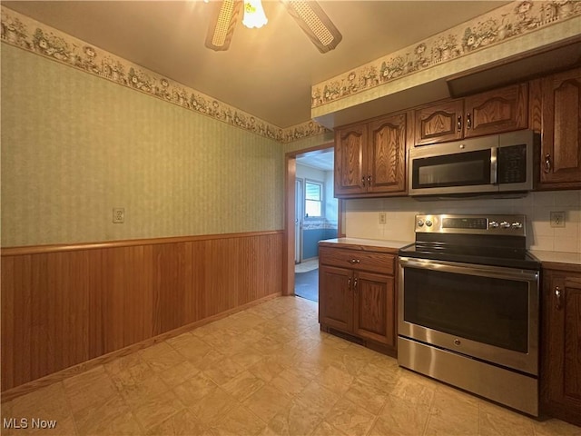 2178 Hewitt Gifford Rd SW, Warren, OH 44481 - kitchen featuring stainless steel appliances, wainscoting, light flooring, wallpapered walls, and light countertops