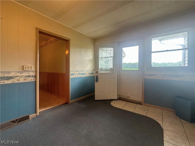 2178 Hewitt Gifford Rd SW, Warren, OH 44481 - entrance foyer with lofted ceiling, wainscoting, wood walls, and light tile patterned flooring