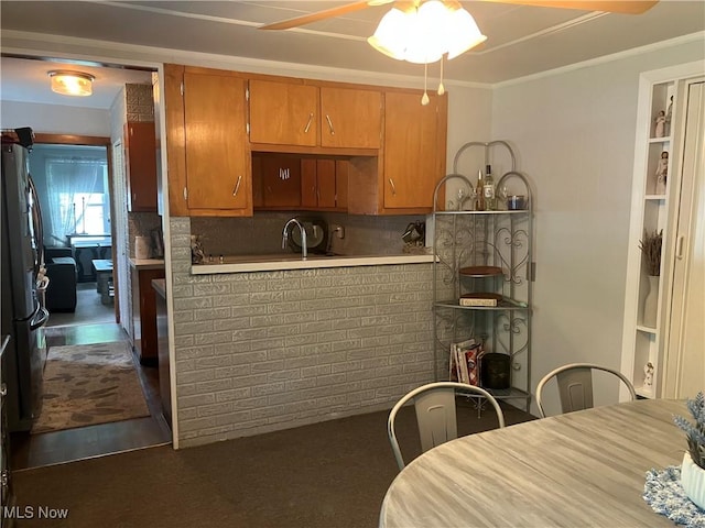 723 High Ave, Niles, OH 44446 - kitchen featuring ceiling fan, backsplash, ornamental molding, light countertops, and brown cabinetry