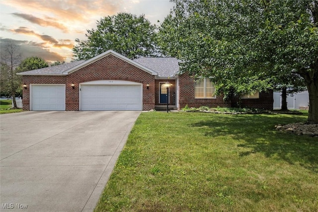 1012 Woodland Chase, Grafton, OH 44044 - view of front of house featuring brick siding, a front yard, driveway, and an attached garage