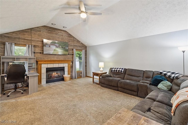 1012 Woodland Chase, Grafton, OH 44044 - living room featuring wooden walls, vaulted ceiling, ceiling fan, a tiled fireplace, and light carpet