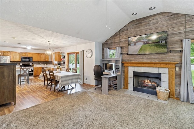 1012 Woodland Chase, Grafton, OH 44044 - living area featuring lofted ceiling, light wood finished floors, a tile fireplace, and wooden walls