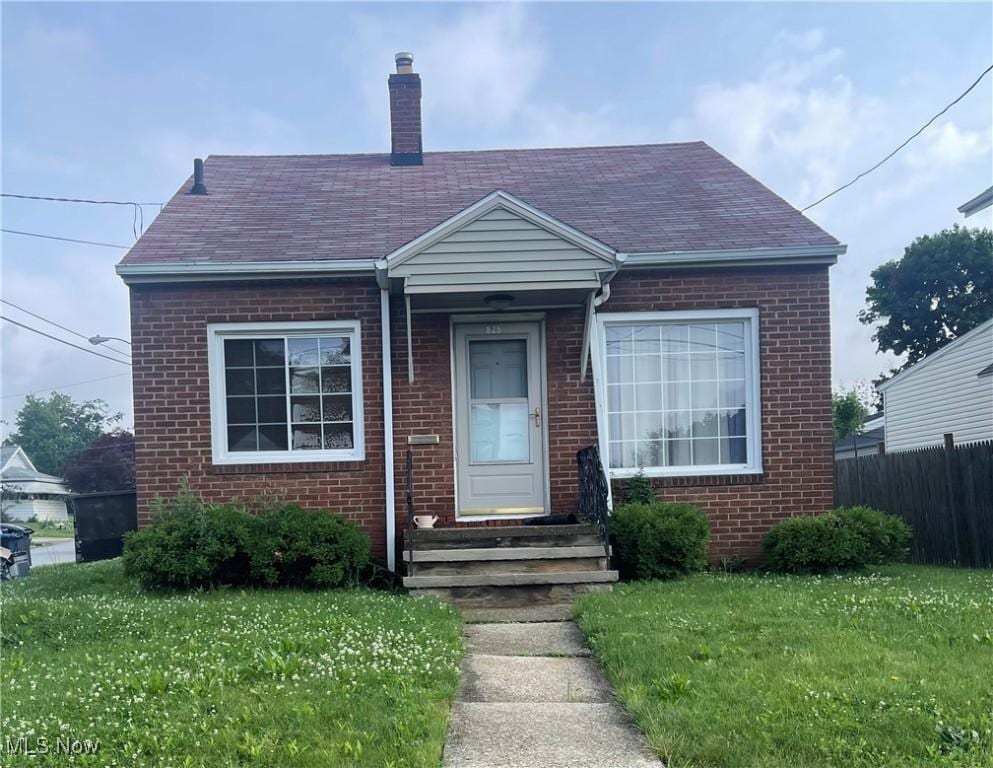 825 Silvercrest Ave, Akron, OH 44314 - view of front of home with brick siding, a chimney, and roof with shingles