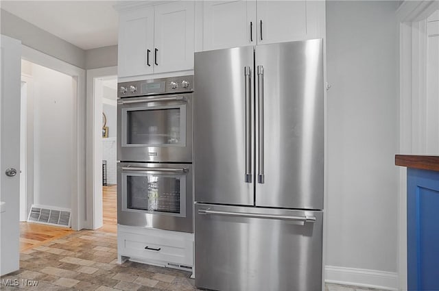 3382 Ormond Rd, Cleveland Heights, OH 44118 - kitchen featuring stainless steel appliances, white cabinets, and brick patterned floors