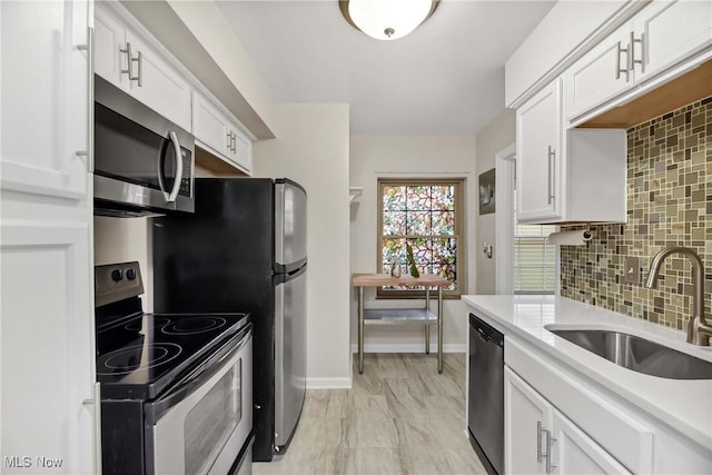 15875 Van Aken Blvd Unit 101C, Shaker Heights, OH 44120 - kitchen with stainless steel appliances, light countertops, white cabinetry, and decorative backsplash
