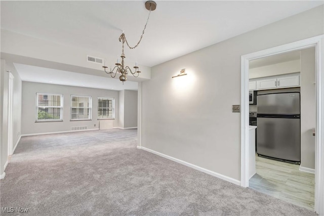 15875 Van Aken Blvd Unit 101C, Shaker Heights, OH 44120 - unfurnished dining area featuring a chandelier and light colored carpet