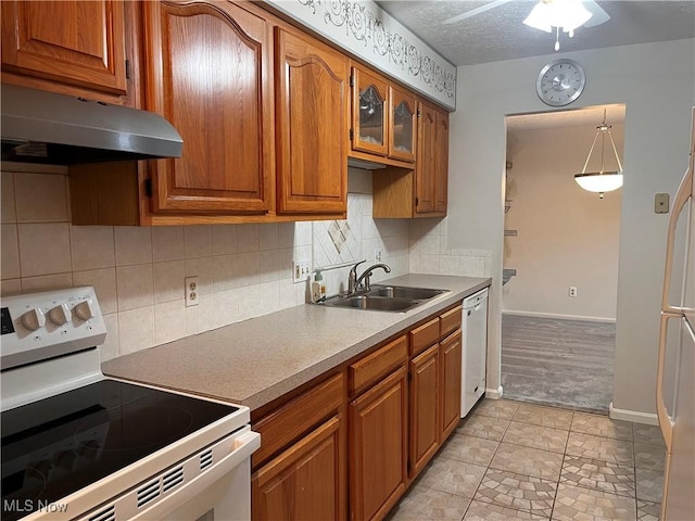1235 Canyon View Rd, Sagamore Hills, OH 44067 - kitchen featuring white appliances, under cabinet range hood, brown cabinets, tasteful backsplash, and light countertops