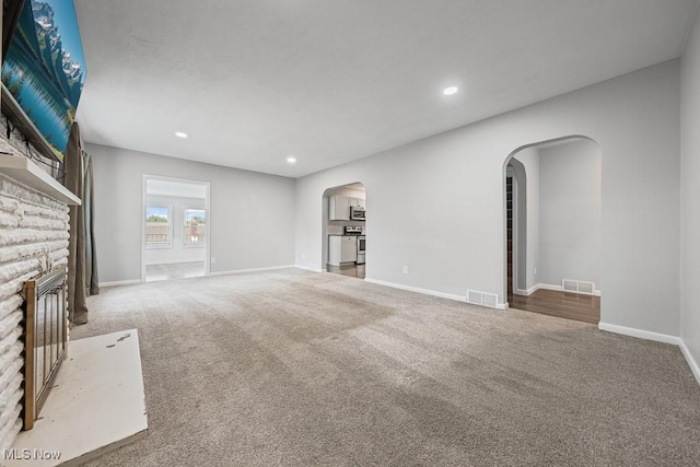 2515 Saratoga Ave SW, Canton, OH 44706 - unfurnished living room with arched walkways, carpet, a fireplace, and recessed lighting