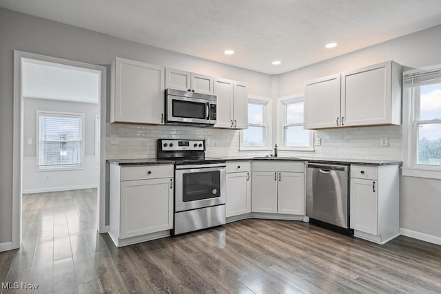 2515 Saratoga Ave SW, Canton, OH 44706 - kitchen featuring appliances with stainless steel finishes, dark countertops, dark wood-type flooring, tasteful backsplash, and recessed lighting