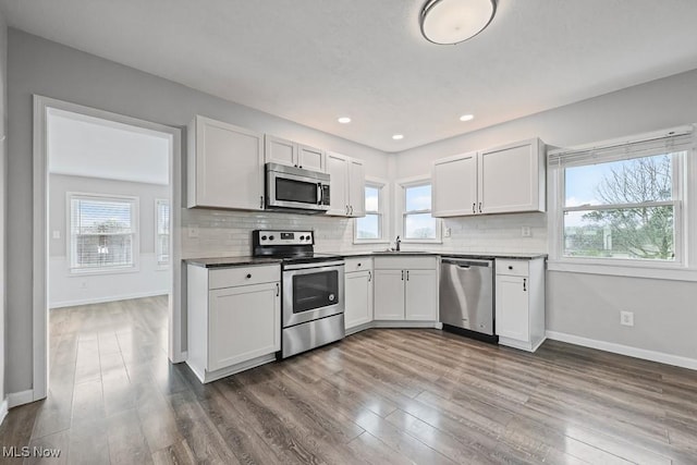 2515 Saratoga Ave SW, Canton, OH 44706 - kitchen with appliances with stainless steel finishes, dark wood finished floors, backsplash, healthy amount of natural light, and recessed lighting