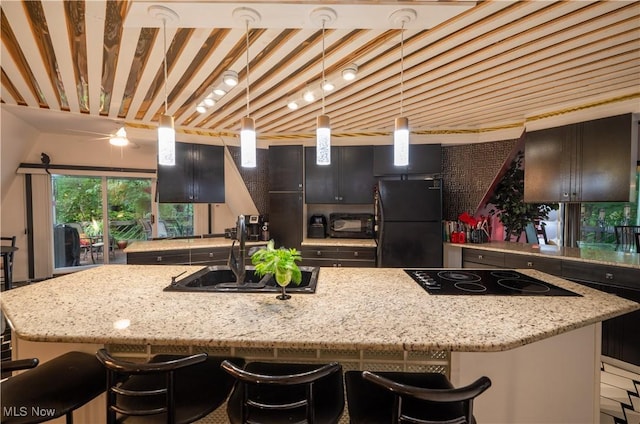 265 Schneiders Crossing Rd NW, Dover, OH 44622 - kitchen featuring black appliances, a large island with sink, a breakfast bar area, and light stone countertops