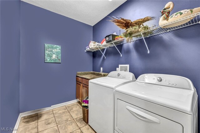 3845 Windsor Bridge Cir, Huron, OH 44839 - laundry room featuring cabinet space, washer and clothes dryer, light tile patterned floors, and a textured ceiling