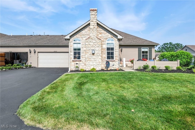 3845 Windsor Bridge Cir, Huron, OH 44839 - view of front facade with driveway, a front lawn, stone siding, an attached garage, and roof with shingles