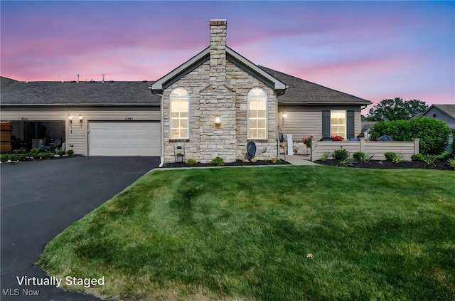 3845 Windsor Bridge Cir, Huron, OH 44839 - view of front of home featuring driveway, stone siding, an attached garage, a lawn, and roof with shingles
