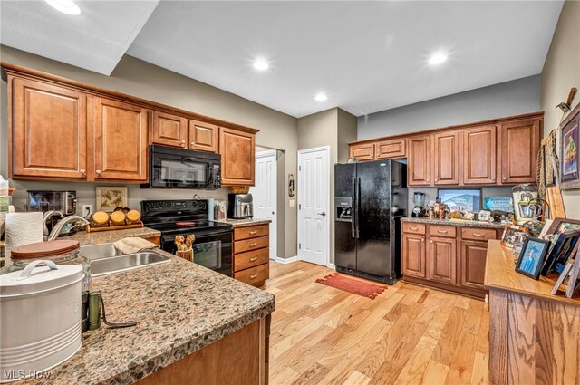 3845 Windsor Bridge Cir, Huron, OH 44839 - kitchen featuring black appliances, brown cabinetry, light wood-type flooring, and recessed lighting