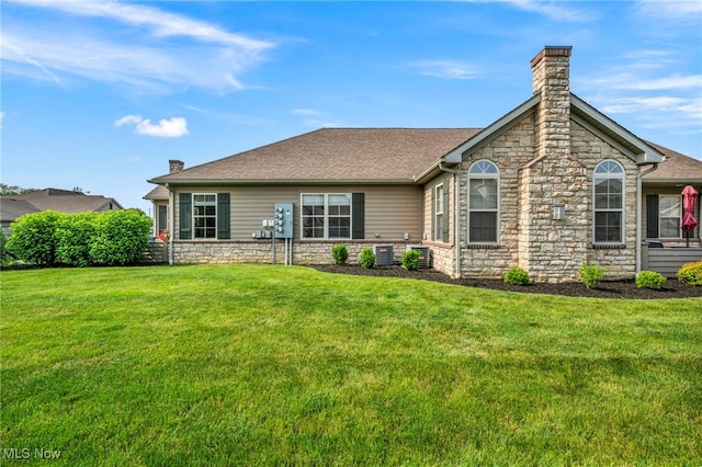 3845 Windsor Bridge Cir, Huron, OH 44839 - back of property featuring a chimney, a yard, stone siding, and roof with shingles