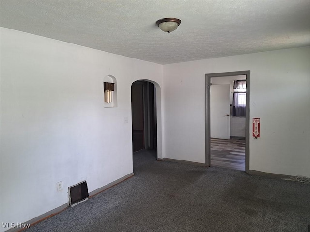 2239 N Ridge Rd E, Lorain, OH 44055 - empty room with arched walkways, a textured ceiling, and carpet