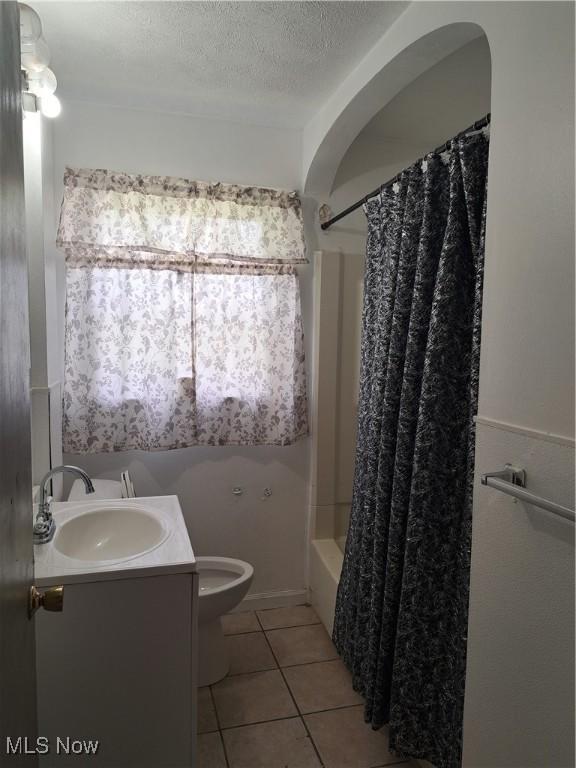 2239 N Ridge Rd E, Lorain, OH 44055 - full bathroom with tile patterned floors, vanity, shower / bath combo, and a textured ceiling